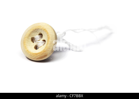 closeup of detached button and thread over white Stock Photo