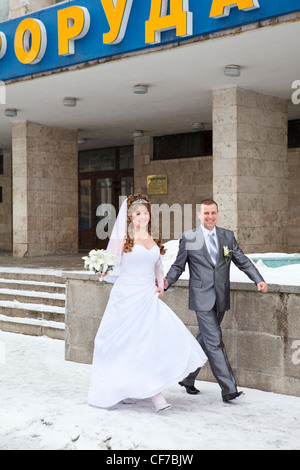 Young Russian just married people going on snowy earth in winter time. Saint-Petersburg, Russia Stock Photo