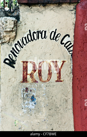 picturesque old semi obliterated Mexican shoe repair shop sign graphic street art painted on crumbling plaster wall Oaxaca de Juarez Mexico Stock Photo