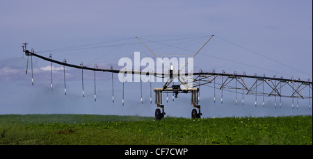 A large pivot irrigation system supplies water to dry crops Stock Photo