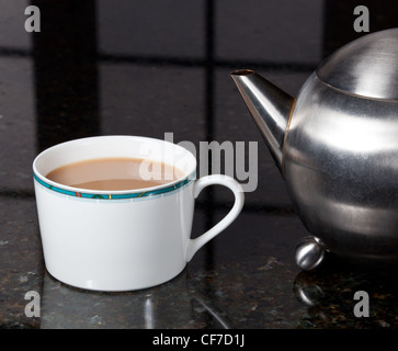 Fresh tea poured into white cup on marble kitchen worktop Stock Photo