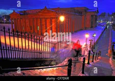 National Gallery of Scotland at dusk in winter,viewed from the Playfair Steps on The Mound in Edinburgh,with snow-covered steps, glowing street lights Stock Photo