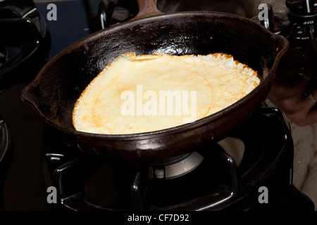 Frying pan on gas stove with pancake mixture being cooked Stock Photo