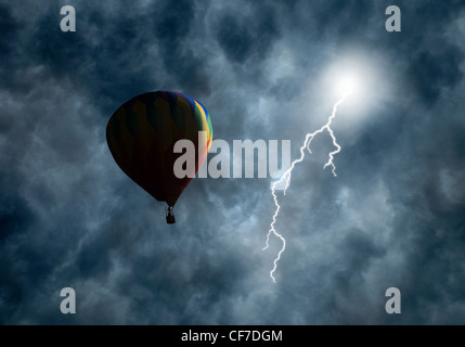 Lightning bolt coming from dark storm clouds toward hot-air balloon Stock Photo