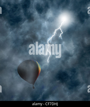 Lightning bolt coming from dark storm clouds toward hot-air balloon Stock Photo