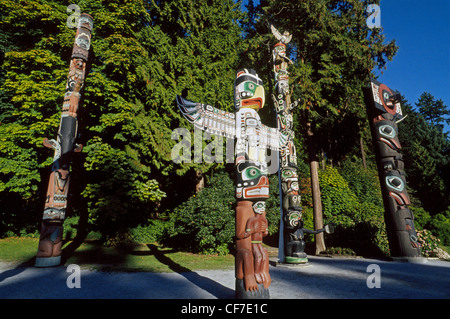 Figures and symbols of importance to First Nation peoples are carved into colorful wooden totem poles displayed in Vancouver, British Columbia, Canada. Stock Photo