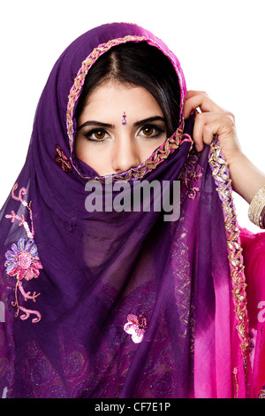 Beautiful Bengali Indian Hindu woman in colorful dress holding veil in front of face, isolated Stock Photo