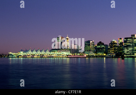 A view from Stanley Park at dusk looks across Vancouver Harbour to the waterfront and downtown skyline of Vancouver in British Columbia, Canada. Stock Photo