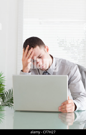 Close up of disappointed businessman looking at his laptop Stock Photo