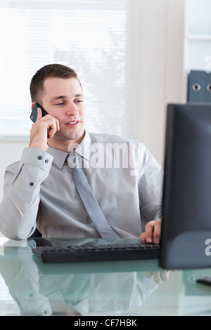 Businessman looking at the screen while on the cellphone Stock Photo