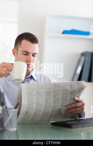 Businessman reading the newspaper and having a coffee Stock Photo