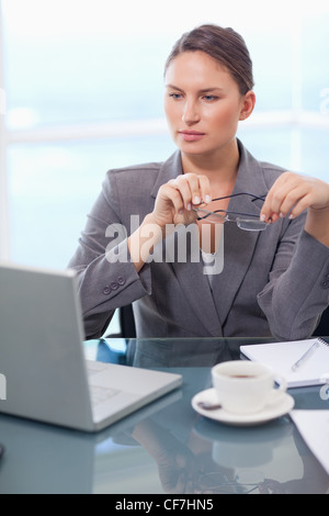 Portrait of a businesswoman putting her glasses on Stock Photo