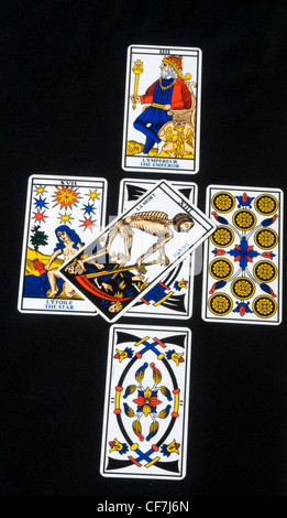 Tarot cards layed out in a cross with the Death card in the middle Stock Photo