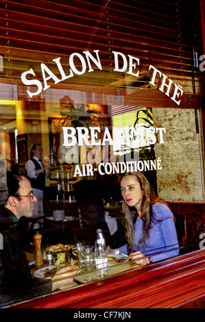 PARIS, France - Couple Sharing Meals in Traditional French Bistro Restaurant 'Camille' in The Marais District. Window with Sign. 'Salon de The' Stock Photo