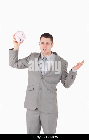 Portrait of a broke businessman shaking an empty piggy bank Stock Photo
