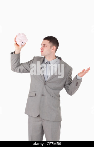 Portrait of a broke businessman looking at an empty piggy bank Stock Photo