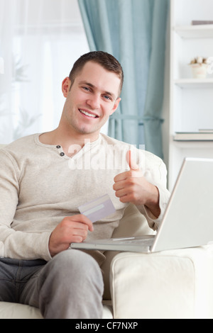 Portrait of a man shopping online with the thumb up Stock Photo