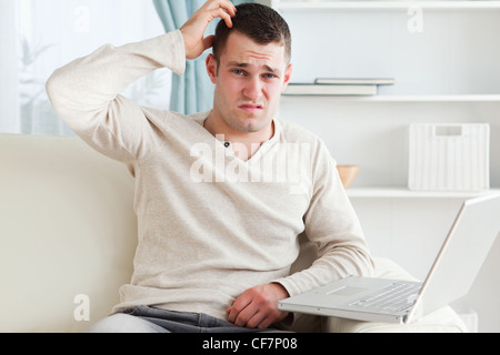 Confused man using a laptop Stock Photo