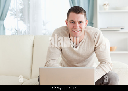 Smiling young man using a notebook Stock Photo