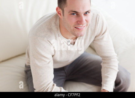 Handsome man sitting on a couch Stock Photo