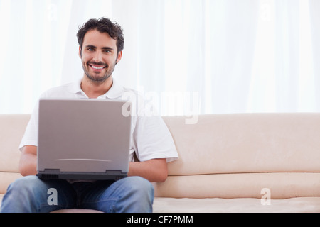 Smiling man using a laptop Stock Photo