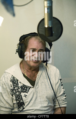 Engelbert Humperdinck UKs Eurovision entery singing in a recording studio with headphones on and singing into a microphone Stock Photo