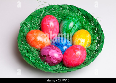 Colored eggs in a basket Stock Photo