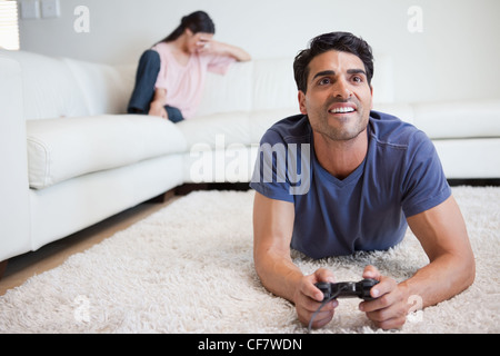 Man playing video games while his fiance is crying Stock Photo