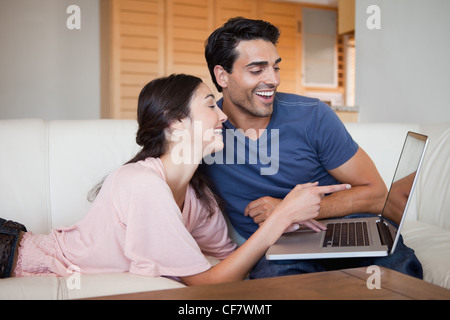Laughing young couple using a laptop Stock Photo