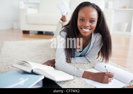 Woman lying on the floor studying Stock Photo