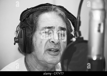 Engelbert Humperdinck UKs Eurovision entery singing in a recording studio with headphones on and singing into a microphone Stock Photo