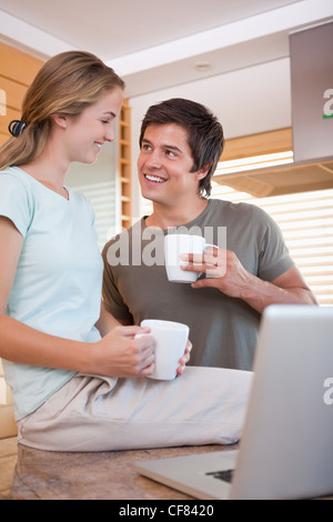 Portrait of a young couple having coffee while using a notebook Stock Photo