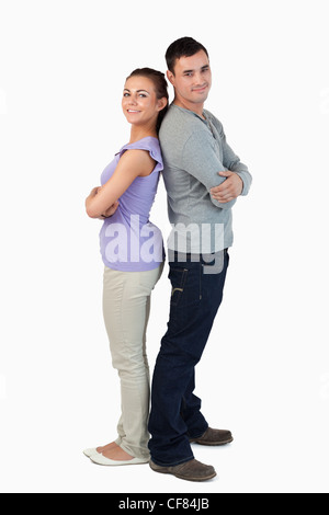 Happy young couple standing back-to back Stock Photo