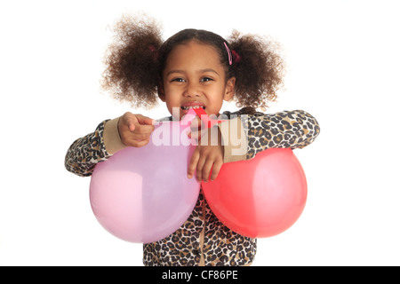 Little girl chewing balloon strings in her mouth Stock Photo by photocreo