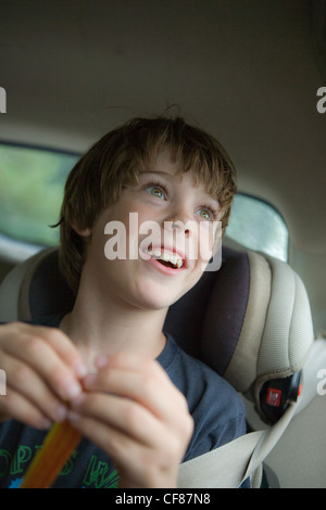 Eight year old boy looking our of car window with expression of wonder and amazement. Stock Photo