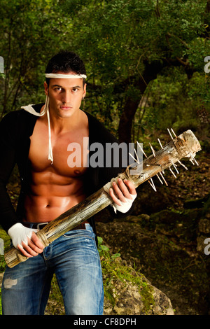 View of a fighter male holding a mace weapon on a forest. Stock Photo