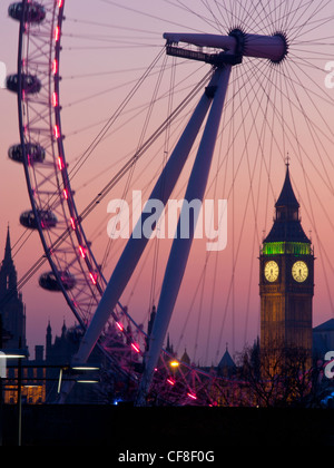 Big Ben Clock Tower of Houses of Parliament seen through Millennium Wheel or London Eye at dusk London England UK Stock Photo