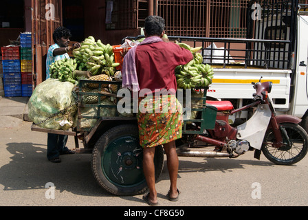 Loading vegetable goods in a Three wheeler Motor cycle.Market scene from Chalai Bazaar of Kerala,India Stock Photo