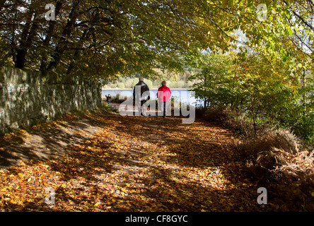 Couple walking at Ogden Water reservoir near Halifax, West Yorkshire, in Autumn. Stock Photo