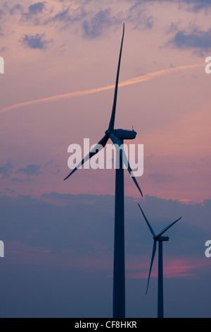 Wind turbines stand tall against a bright blue sky with white clouds ...