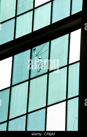 Bullet holes in the glass wall of an airplane hanger on Ford Island from the surprise Japanese attack of Pearl Harbor. Stock Photo