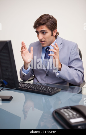 Businessman getting surprised by his computer Stock Photo