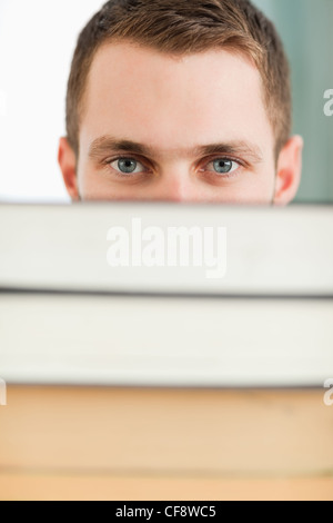 Student behind a pile of books Stock Photo