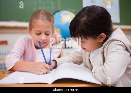 Happy schoolgirls doing classwork Stock Photo - Alamy