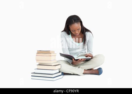 Young woman reading next to stack of books Stock Photo - Alamy