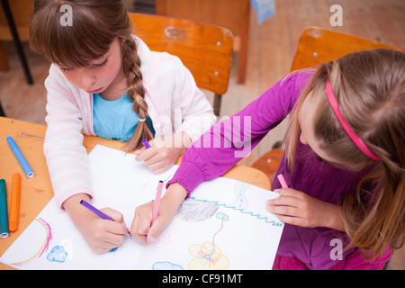 Schoolgirls drawing in a coloring book Stock Photo