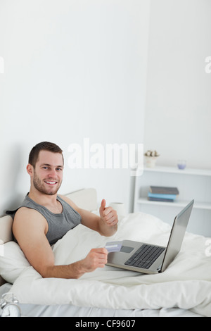 Portrait of a man purchasing online with thumb up Stock Photo