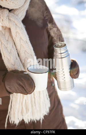 Thermos with a hot drink on mountain waterfall Stock Photo by