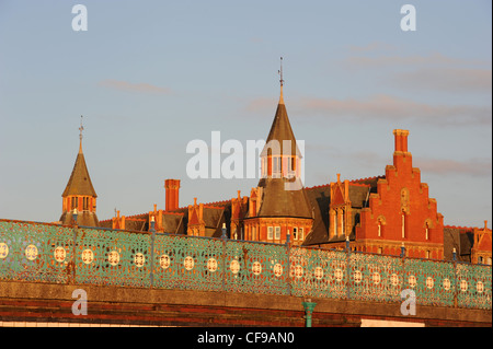 Ornate cast iron railings with filigree, and the Marine Gate buildings on The Promenade, Southport, Merseyside. Seen in colourful low evening light Stock Photo