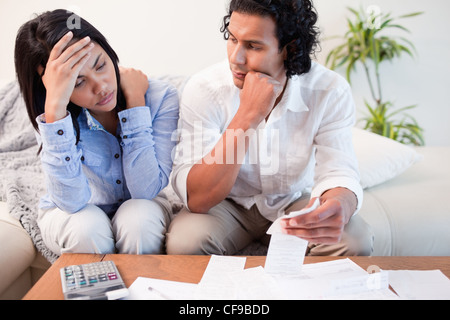 Frustrated couple checking their bills Stock Photo